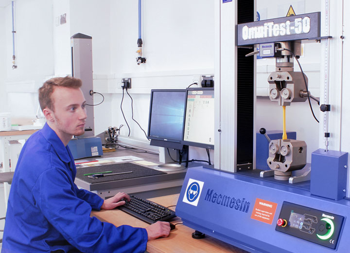 Operator performing materials tenstile test on Mecmesin 50kN universal testing machine