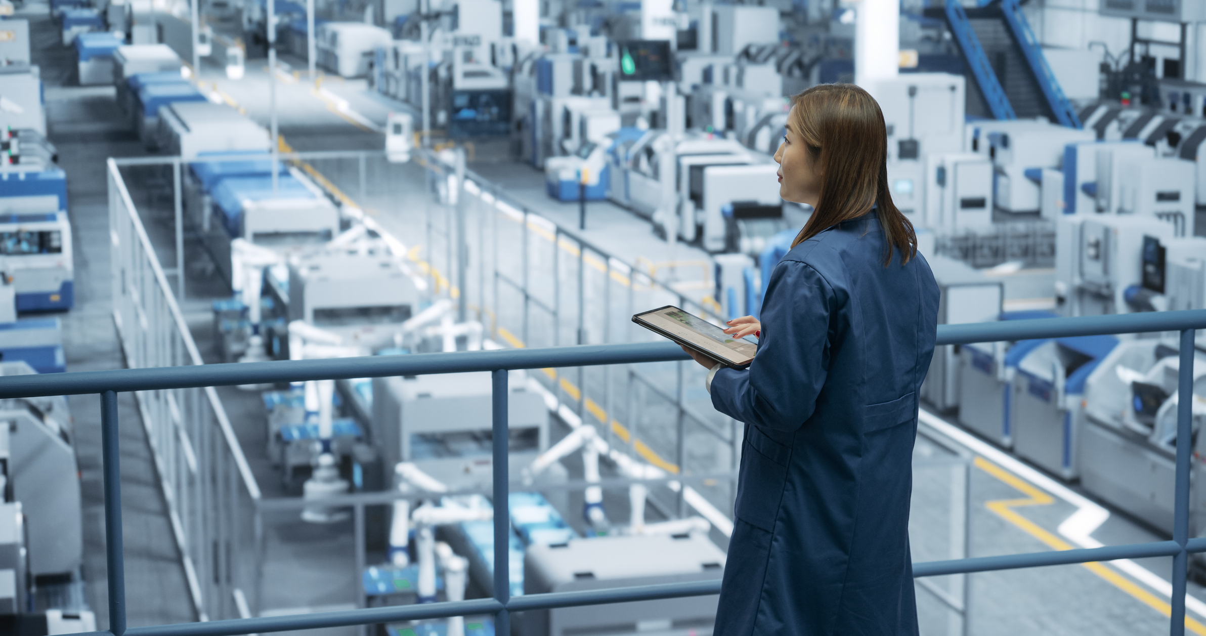 Stock photo of engineer looking out across a manufacturing floor