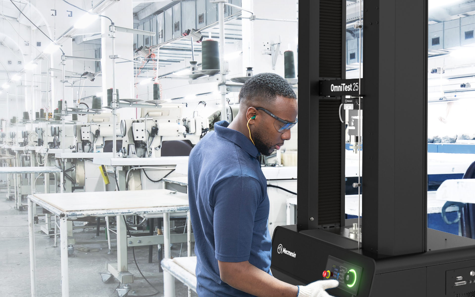 Photo of machine operator in factory environment setting up a universal tester for quality control testing